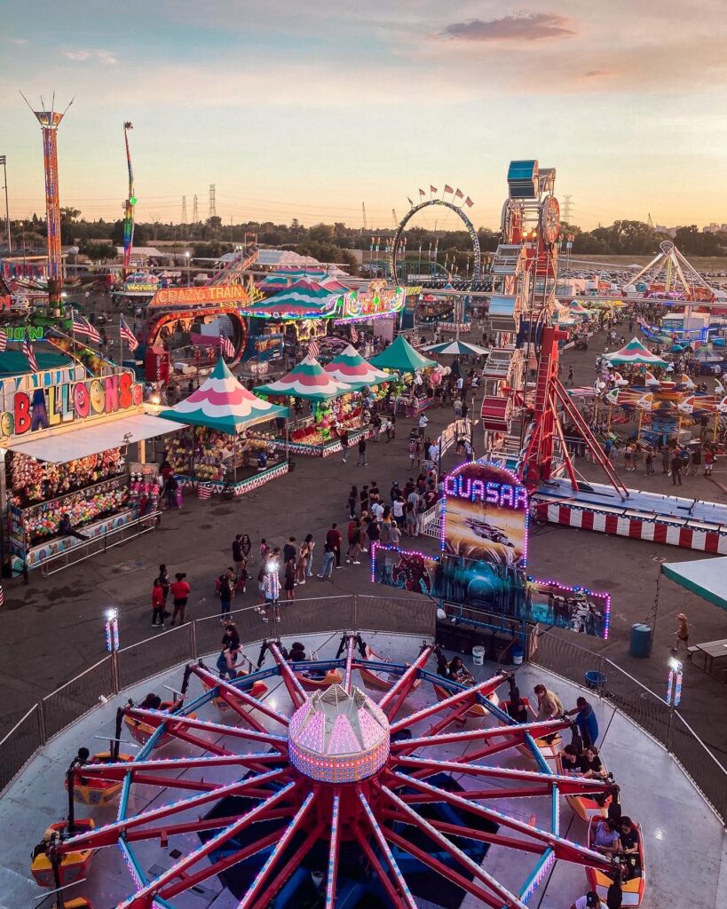 An aerial view of the rides and prize stands in the California State Fair from the skyride, during sunset and golden hour. The California State Fair is one of the most popular summer activities in Sacramento.