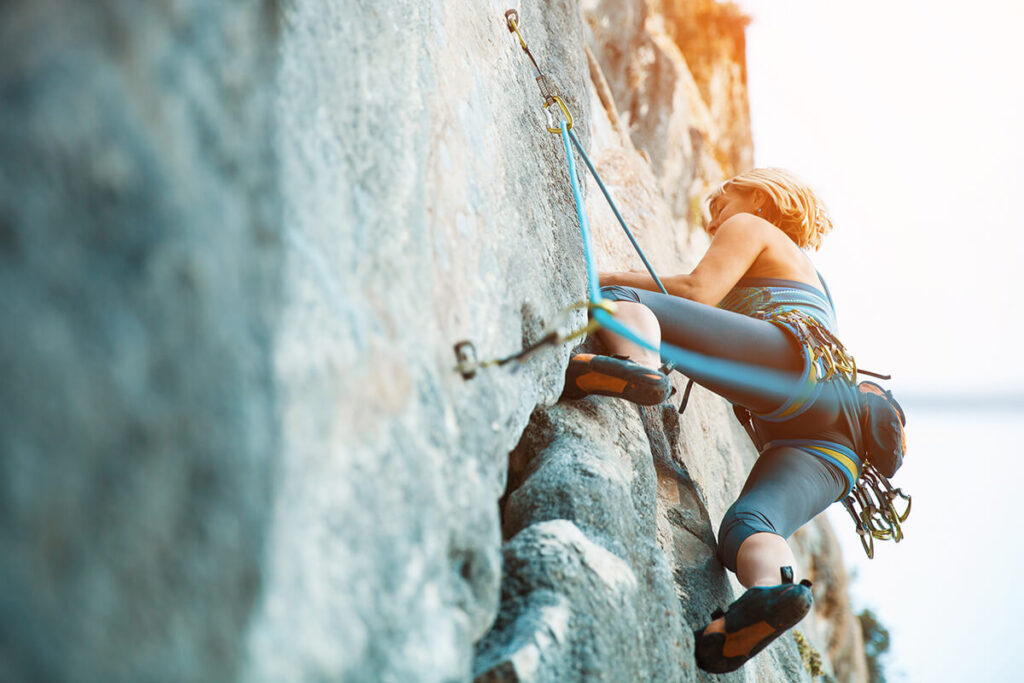 a woman climbing a rock wall